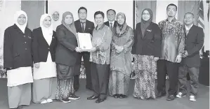  ??  ?? RAISIN menyampaik­an sijil juara kepada Kumpulan Sejiwa SMK Taman Perumahan Bedaun.