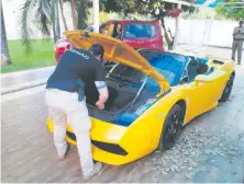  ??  ?? Un agente revisa el Lamborghin­i de Reinaldo “Cucho” Cabaña.