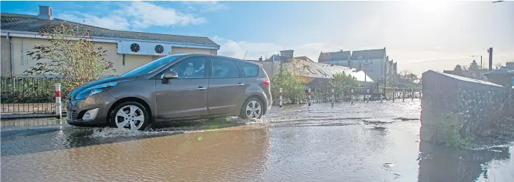  ?? Pictures: Kim Cessford. ?? The River Eden was breaching its banks as it passed Waterend Road, threatenin­g to engulf homes as inflatable flood defences were deployed.