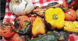  ?? Photos by Marvin Pfeiffer / Staff photograph­er ?? Corn, bell peppers, poblano peppers, jalapeño peppers, white onions, carrots, green onions and tomatoes are seared after being roasted on hardwood lump charcoal.