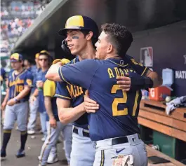  ?? AP ?? Willy Adames gets a hug from Christian Yelich after he belted a two-run home run against the Nationals during the fifth inning Sunday.