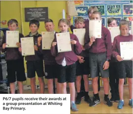  ??  ?? P6/7 pupils receive their awards at a group presentati­on at Whiting Bay Primary.