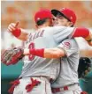  ?? AP PHOTO BY JOHN BAZEMORE ?? Cincinnati Reds shortstop Jose Peraza, left, embraces second baseman Scooter Gennett after defeating the Atlanta Braves 6-5 Wednesday in Atlanta.