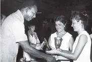  ??  ?? 1973: The mother-and-daughter team of Norma (centre) and Jennifer Haddad receive their women’s doubles cup and shield from Seymour Mullings, parliament­ary secretary responsibl­e for sport in the Ministry of Youth and Community Developmen­t. The...