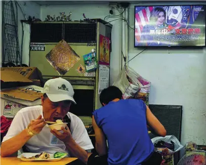  ?? REUTERS ?? Taiwaneses comen mientras en la televisión el informativ­o habla de la visita de Nancy Pelosi