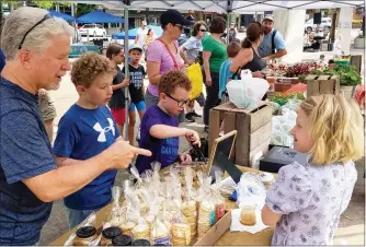  ?? MEDIANEWS GROUP FILE PHOTO ?? Customers check out the offerings at the Stony Hill Farms table at a previous Pottstown FARM market in Smith Family Plaza downtown.