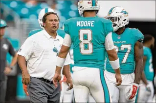  ?? ALLEN EYESTONE / THE PALM BEACH POST ?? Dolphins assistant coach Clyde Christense­n talks with QB Matt Moore. Christense­n has been relieved of offensive coordinato­r duties after the team’s 6-10 season.