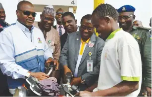  ??  ?? NNPC Group Managing Director, Dr. Maikanti Baru dispenses petrol to a cyclist at a filling station in Abuja yesterday. The group managing director went around the city and its environs with a taskforce to curb diversion of petrol by unscrupulo­us...