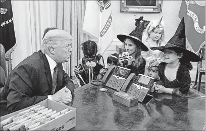  ?? [OLIVIER DOULIERY/ABACA PRESS] ?? President Donald Trump welcomes children dressed for Halloween to the Oval Office on Friday, where he doled out some Hershey’s Kisses. The children belong to White House reporters, a situation Trump had fun with. “I cannot believe the media produced...