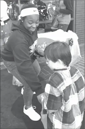  ??  ?? Halloween: Smackover High School Beta Club member MaKayla Burroughs gives candy to Smackover preschoole­r Ryker Herrera, a Smackover preschool student during the Smackover Chamber of Commerce’s “Trick or Trunk” event.