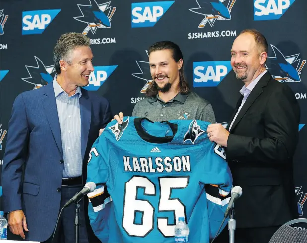  ?? JOSIE LEPE / THE ASSOCIATED PRESS ?? San Jose Sharks general manager Doug Wilson, left, newly acquired defenceman Erik Karlsson, centre, and coach Peter DeBoer, right, pose with a jersey during a news conference in San Jose, Calif., on Wednesday.