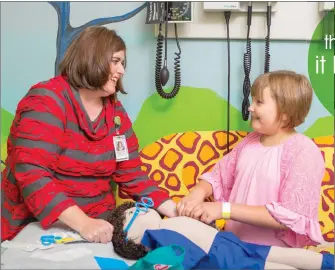  ??  ?? Stephanie Dunlap works with patient at the Arkansas Children’s Hospital Clinic in Lowell.