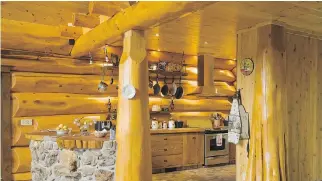  ??  ?? The kitchen’s natural stone bar is inlaid with two red cedar wood countertop­s cut from the base of the trees.