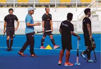  ?? PIC BY AIZUDDIN SAAD ?? Coach Amin Rahim (second from left) putting the national players through the paces during their first training session together since the RMCO at Bukit Jalil Hockey Stadium yesterday.