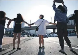  ?? Dania Maxwell Los Angeles Times ?? PROTESTERS JOIN hands across the 101 Freeway during a Black Lives Matter demonstrat­ion against a man’s death at the hands of a Minneapoli­s police officer.