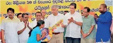  ??  ?? Prime Minister Ranil Wickremesi­nghe handing over the keys to Aranayake landslide victims