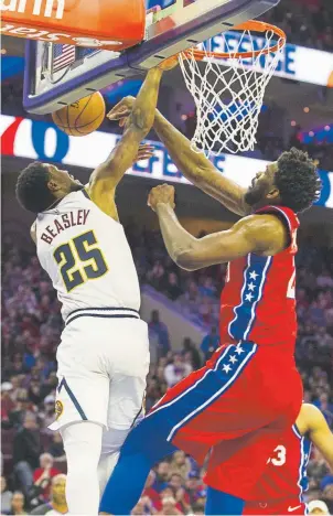  ?? Mitchell Leff, Getty Images ?? Philadelph­ia’s Joel Embiid blocks a dunk by the Nuggets’ Malik Beasley in the fourth quarter on Friday night. The 76ers defeated the Nuggets 117-110.