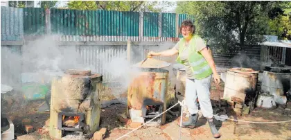  ?? Photo/File ?? Sue Emeny
Sarah Kuggeleijn stokes the cauldrons of boiling dyes at last year’s Dannevirke Spinners and Weavers annual dye day.