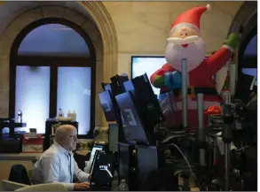  ?? (AP/Seth Wenig) ?? An inflatable Santa overlooks traders Monday on the floor at the New York Stock Exchange. Concerns about the economic effect of covid lockdowns in China helped push stocks lower Monday.