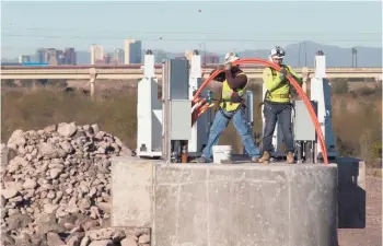  ?? MARK HENLE/THE REPUBLIC ?? Once the lake is emptied, work can begin on removing the rubber dam on both the west and east ends of Tempe Town Lake. Work also will be completed on the new west-end dam, west of the rubber structure that rests beneath a pedestrian walkway.