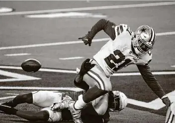  ?? Michael Ainsworth / Associated Press ?? Cardinals safety Budda Baker strips the ball from the Cowboys’ Ezekiel Elliott in the first half — one of Elliott’s two lost fumbles that Arizona converted to 14 points in Dallas’ 38-10 home loss Monday night.