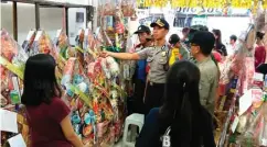  ?? DRIAN BINTANG SURYANTO/JAWA POS ?? ANTISIPATI­F: Kompol Ari Tresetiawa­n memeriksa salah satu toko penjual parsel di Jalan Genteng kemarin.