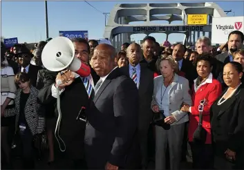  ?? KEVIN GLACKMEYER — THE ASSOCIATED PRESS FILE ?? U.S. Rep. John Lewis, D-Ga., center, talks with those gathered on the historic Edmund Pettus Bridge during the 19th annual reenactmen­t of the “Bloody Sunday” Selma to Montgomery civil rights march across the bridge in Selma, Ala. The Selma Bridge Crossing Jubilee was the first without the towering presence of Lewis, as well as the Rev. Joseph Lowery, the Rev. C.T. Vivian and attorney Bruce Boynton, who all died in 2020.