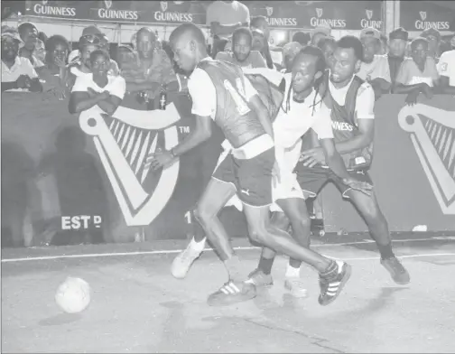  ??  ?? Daniel Favourite (centre) of Broad Street tussling with two Queen Street Tiger Bay players, during their group clash in the Guinness СGreatest of the Streets Georgetown Zone at the National Cultural Centre tarmac.