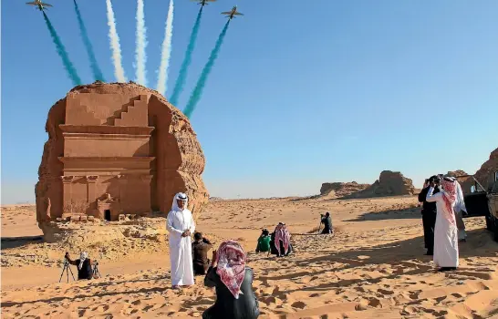  ?? VIVIAN NEREIM/WASHINGTON POST ?? Saudi visitors watch an aerial flying display over Mada’in Saleh, a Unesco World Heritage site.