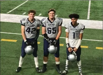  ?? Courtesy photo ?? From left to right: Hart football players Trevor Laibl, Nathan Bradder and DJ Palmer stand on the field at AT&T Stadium in Arlington, Texas for the Blue-Grey American game on Monday.