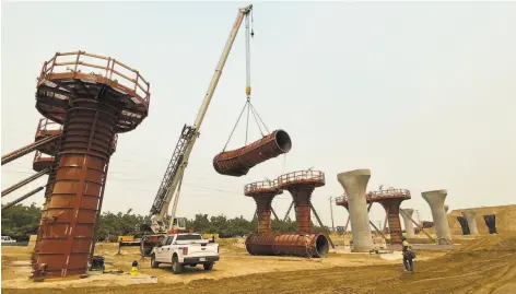  ?? California High-Speed Rail Authority 2020 ?? Crews hoist forms into place in August before concrete is poured to form a column on the Hanford Viaduct in Kings County.