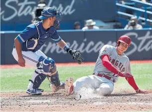  ?? RICHARD LAUTENS/TORONTO STAR ?? Angels’ Shohei Ohtani slides safely into home as Jays catcher Luke Maile awaits the late throw.