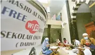  ?? AHMAD KHUSAINI/ JAWA POS ?? SEDEKAH WIFI: Muhammad Izza Nasrullah bersiap mengikuti belajar online di Masjid At Taqwa kemarin. Foto kanan, belajar bareng di Masjid At Taqwa hanya berlangsun­g pada pukul 08.00 sampai 11.00.