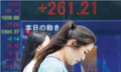  ??  ?? TOKYO: People walk by an electronic stock board of a securities firm in Tokyo yesterday. Asian stocks rose strongly Monday after Hurricane Irma weakened and North Korea marked a weekend holiday with celebratio­ns but refrained from launching more...