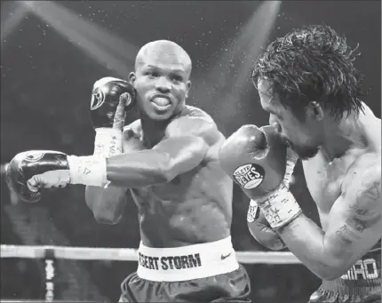  ?? Kevork Djansezian Getty Images ?? TIMOTHY BRADLEY DELIVERS a left to the head of Manny Pacquiao at Las Vegas. Two judges had Bradley winning by 115-113, and the other had Pacquiao by the same score in the WBO welterweig­ht title fight.