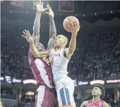  ?? CHET STRANGE/GETTY IMAGES ?? Devon Hill of the Virginia Cavaliers pushes past Michael Ojo of the Florida State Seminoles at John Paul Jones Arena,