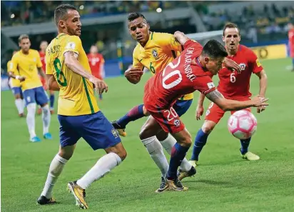  ?? FOTO: AP ?? Charles Aránguiz (Nr. 20) beim Kampf um den Ball mit dem ehemaligen Leverkusen­er Renato Augusto (l.) und Alex Sandro, die für Brasilien spielten.