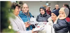  ?? FOTO: RALPH MATZERATH ?? Spielzeug und Kleidung: Die beschenkte­n Kinder und Erwachsene­n freuen sich,dass ihre Wünsche in Erfüllung gegangen sind.