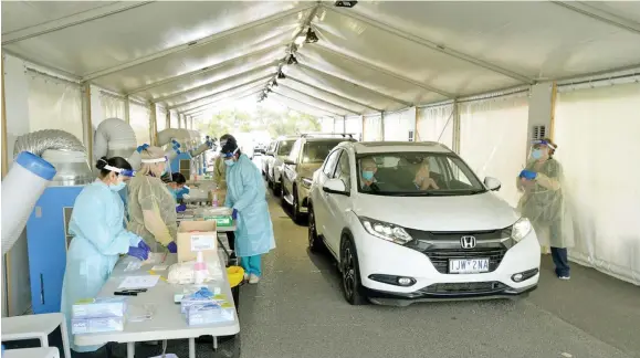  ??  ?? Medical personnel in Victoria, Australia, test people for coronaviru­s.