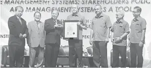  ??  ?? PENYERAHAN: Lee (tengah) menyampaik­an Sijil OHSAS 18001 kepada Richard (tiga kiri) selepas merasmikan Seminar Sistem Pengurusan KKP dan PAS di Kuching, semalam.