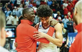  ?? DAVID JABLONSKI / STAFF ?? Dayton coach Anthony Grant and forward Nate Santos hug after a victory against Nevada in the first round of the NCAA Tournament on March 21 in Salt Lake City, Utah. Santos entered the transfer portal on April 28 but announced Saturday he will play the 2024-25 season with Dayton.