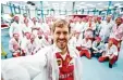  ?? Foto: dpa ?? Sebastian Vettel posiert im Ferrari Werk von Maranello mit Mitarbeite­rn.