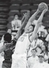  ?? Eric Gay / Associated Press ?? UT forward Jericho Sims, right, pulls down a rebound over Louisiana-Monroe guard JD Williams during the first half Monday. Sims had five rebounds to go with three points.