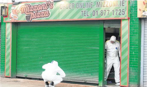  ?? PHOTO: GARETH CHANEY/COLLINS ?? Murder bid: Forensics gardaí at the scene of the shooting at a takeaway in Edenmore, Dublin.