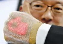  ??  ?? THIS photo taken on Feb. 14 shows a man holding an ultra-thin elastic display equipped with a light emitting diode, newly developed by Professor Takao Someya of Tokyo University, in Tokyo.