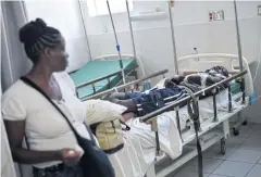 ?? AFP ?? The victim of a transit accident is accompanie­d by relatives at La Providence Hospital on Sunday in Gonaives, 150km northwest of the Haiti capital Port-au-Prince.