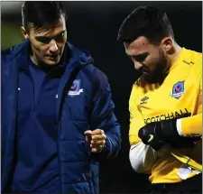  ?? Pic: Sportsfile ?? Ross Treacy leaves the field at Oriel Park with an arm injury, alongside Drogheda United physio David Cooke.