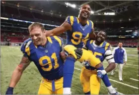  ?? ASSOCIATED PRESS FILE PHOTO ?? Chris Long, left, helps carry fellow Rams defensive end Robert Quinn off the field with William Hayes, right, after Quinn set a team single-season sacks record in a game in 2013.