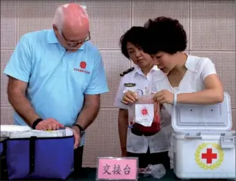  ?? JIANG MENG / FOR CHINA DAILY ?? Robert Panza of the US marrow donor program, accepts Zhao Yuedong’s marrow on Tuesday from Li Mu, director of the Liaoning branch of the donor program. Zhao, 39, wrote to the recipient, “Don’t be afraid ... remember, I’m here with you.”