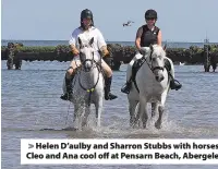  ??  ?? Helen D’aulby and Sharron Stubbs with horses Cleo and Ana cool off at Pensarn Beach, Abergele